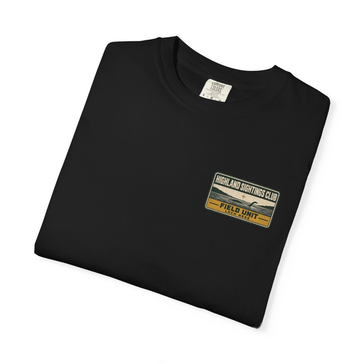 Close-up of the Highland Sightings Club print on a folded black tee