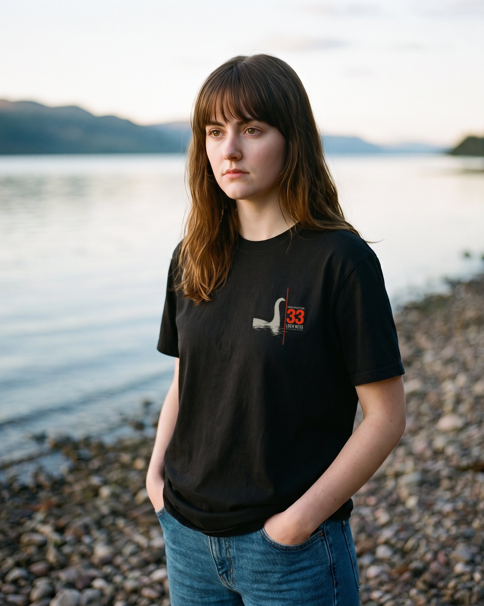 A person wearing the Observation 33 tee in black on location near Loch Ness, Scotland