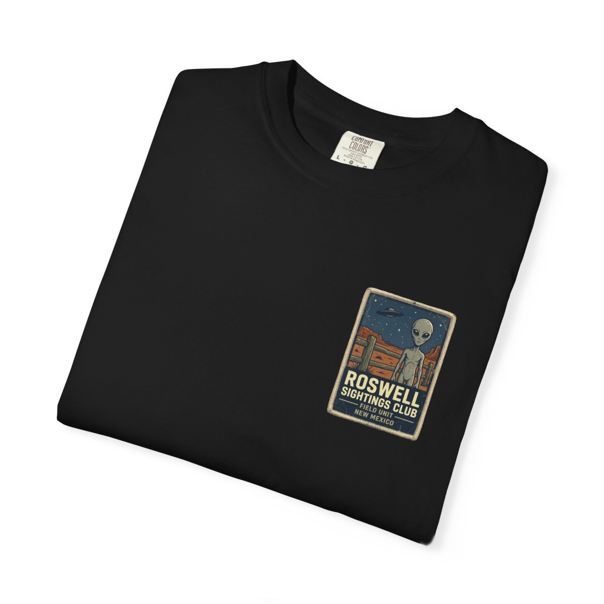 Close-up of the Roswell Sightings Club print on a folded black tee