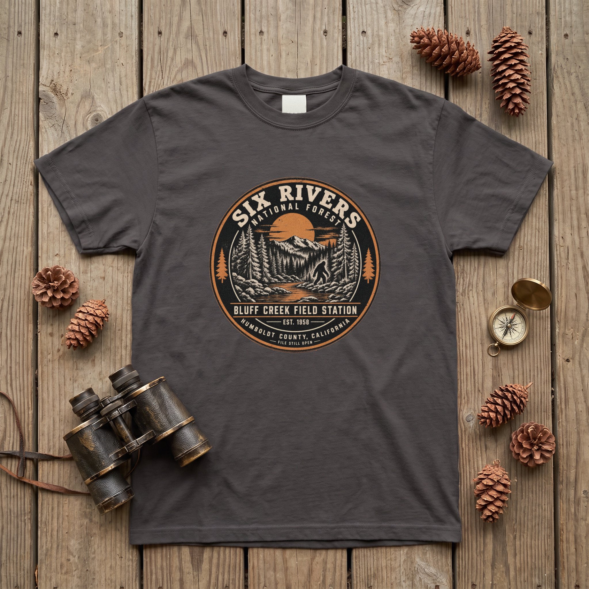 The Six Rivers Field Station tee in graphite laid flat with field kit from the Bigfoot file