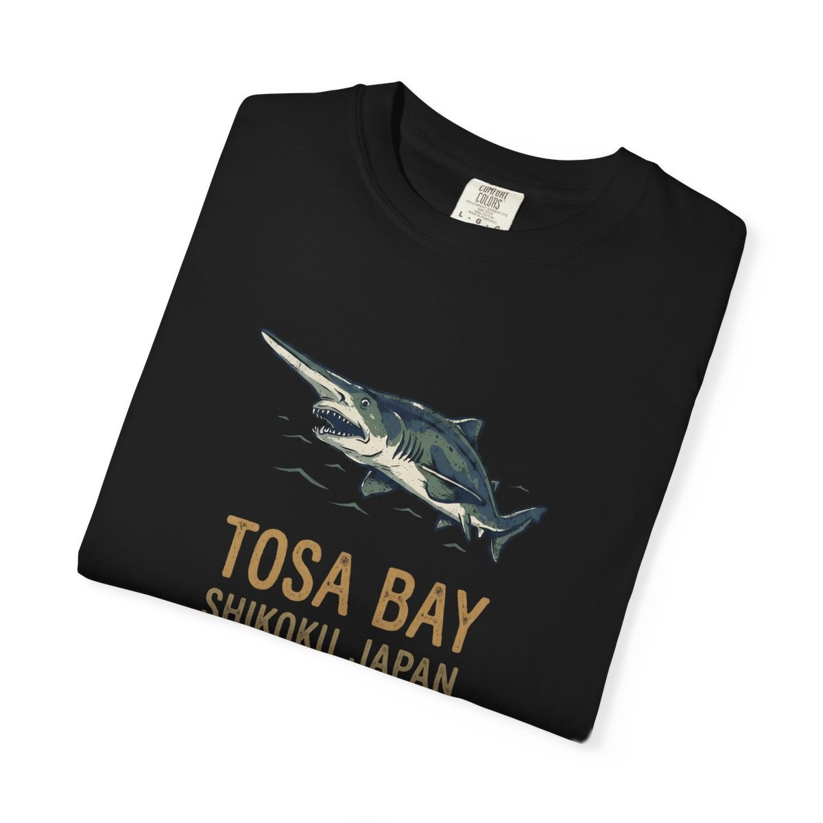 Close-up of the Tosa Bay Souvenir print on a folded black tee