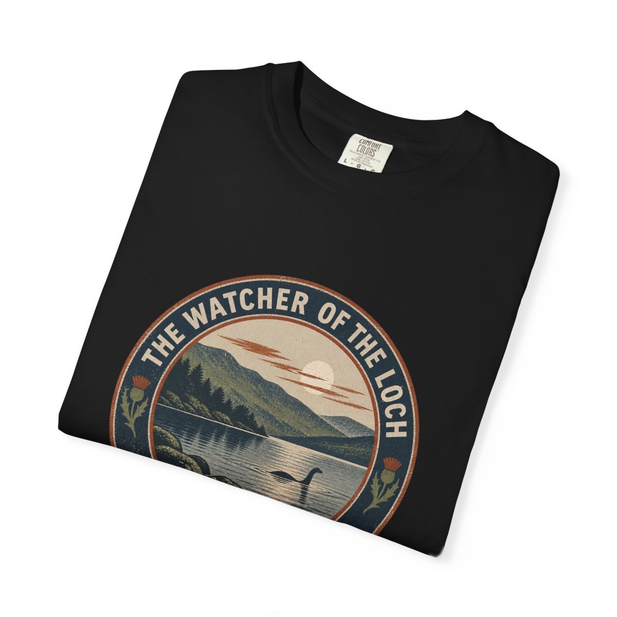 Close-up of the Watcher of the Loch print on a folded black tee